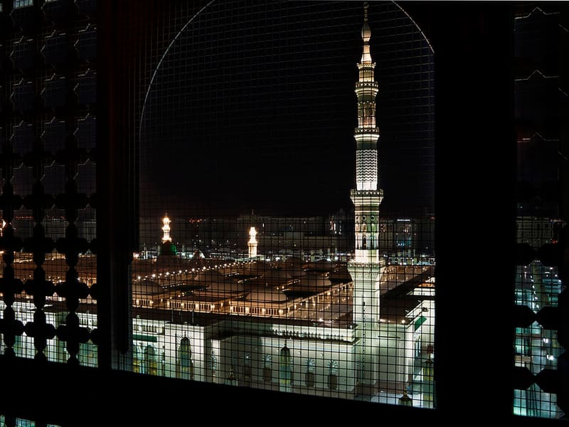 Masjid an-Nabawi at night, seen through a hotel window in Madinah