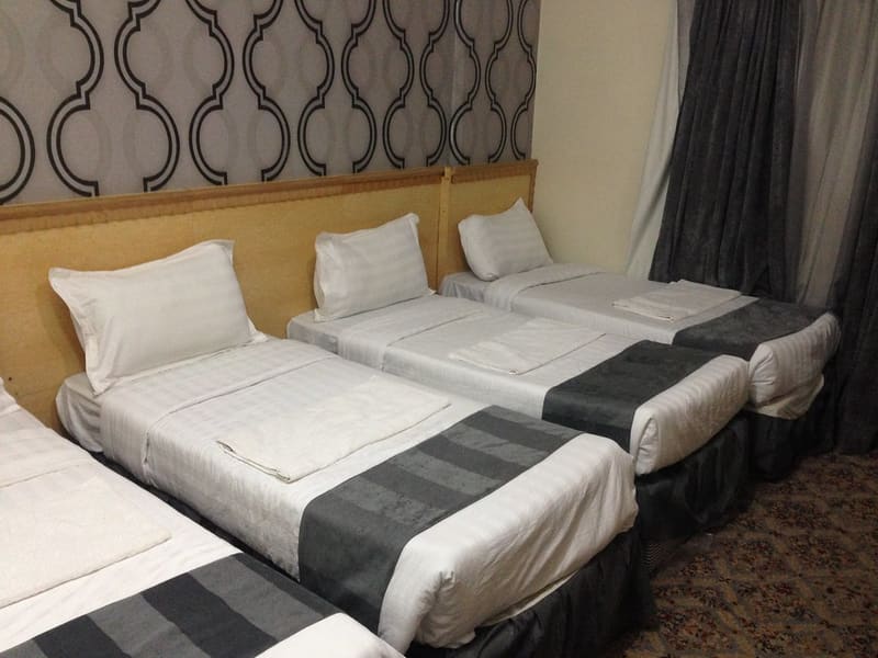 A hotel room in Makkah with beds for a shared stay